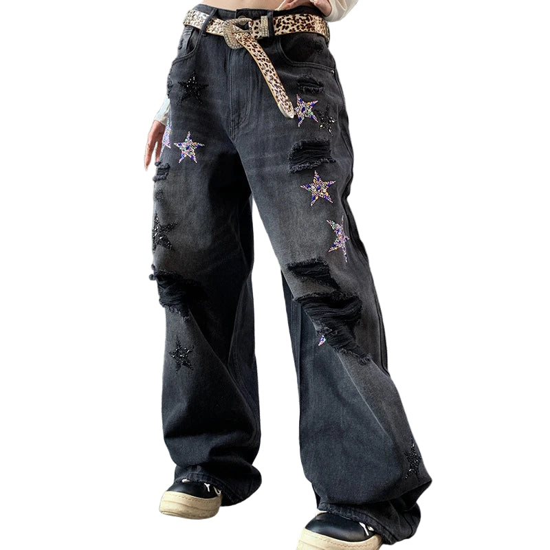 Person wearing black distressed jeans with star patterns.