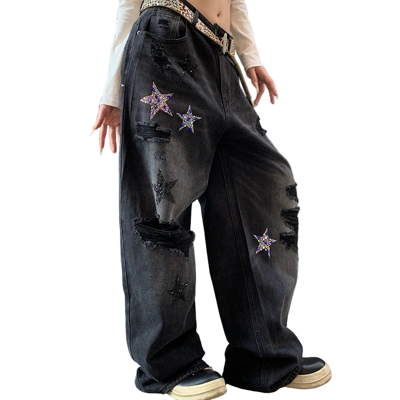 Person wearing black distressed jeans with star patterns.